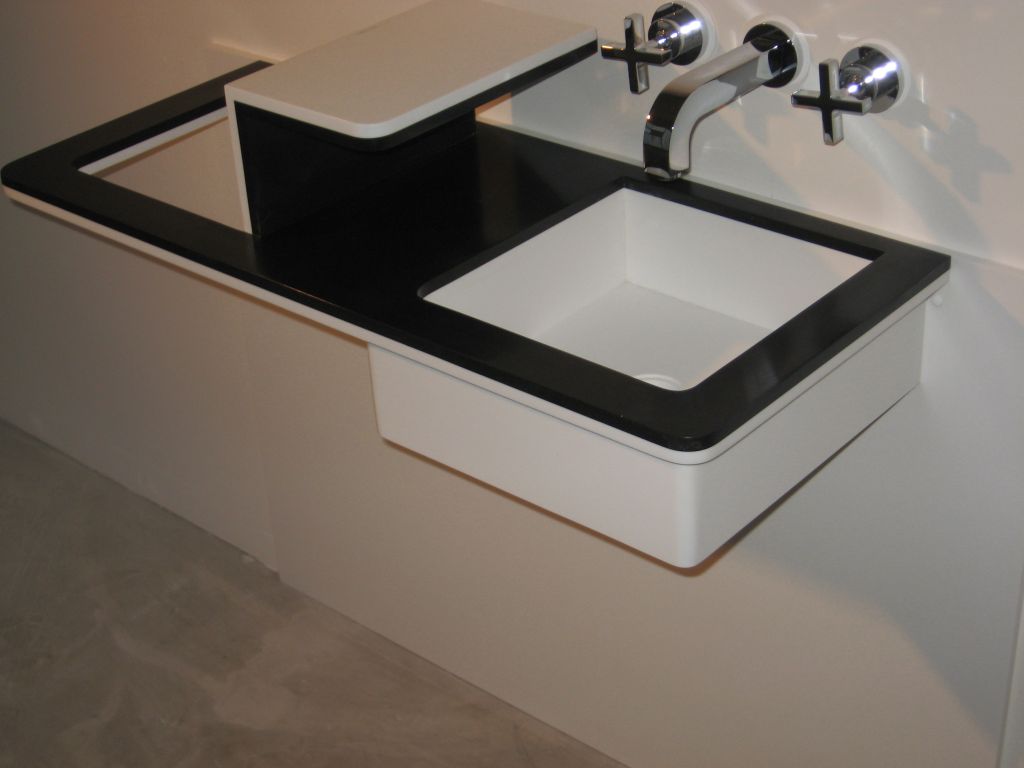 Čtvercové umyvadlo zapuštěné do černé pracovní desky