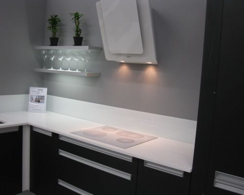 Moderní kuchyňská linka s černými skříňkami a bílou deskou