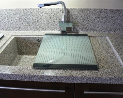 Detail nerezového dřezu s moderní baterií a odkapávačem