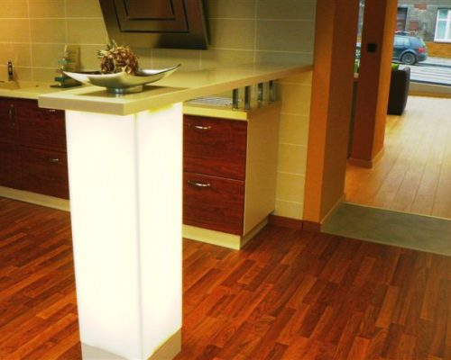 Barový pult s bílou pracovní deskou a dřevěnou podlahou