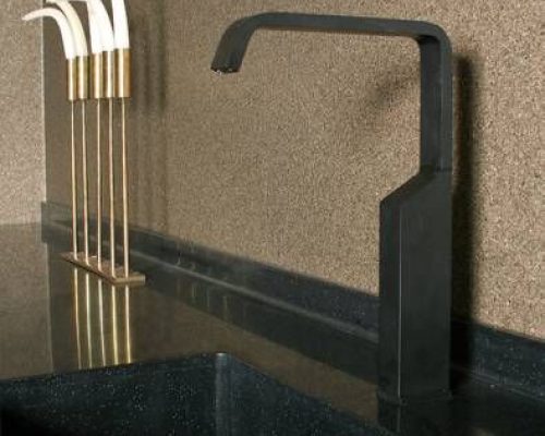 Detail černé kuchyňské baterie s nerezovým dřezem