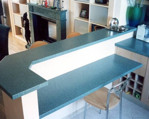 Moderní kuchyň s modrou barovou deskou a černou linkou