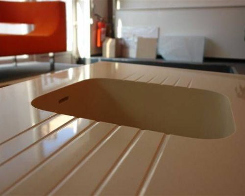 Detail bílé kuchyňské pracovní desky s výřezem na dřez